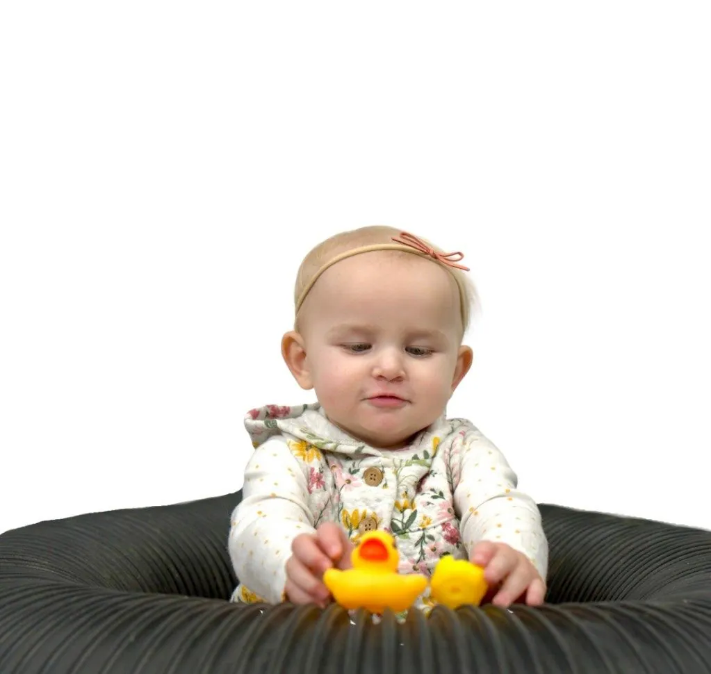 Baby sitting in a duct with rubber ducks