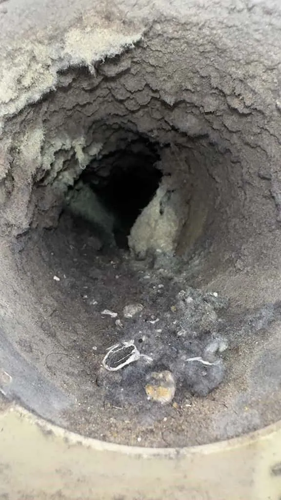 Round dryer vent clogged with lint before cleaning